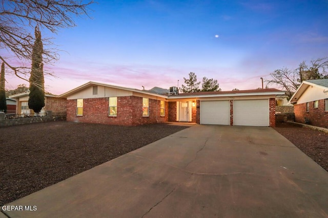 view of front facade featuring driveway, an attached garage, and brick siding