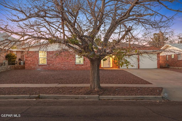 view of front of property with driveway, an attached garage, and brick siding