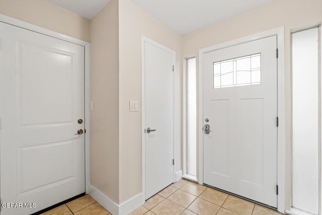 foyer entrance featuring light tile patterned floors and baseboards