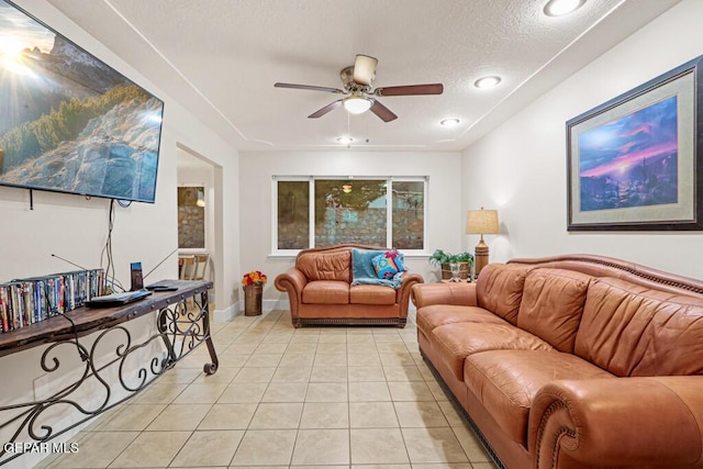 living room with light tile patterned floors, recessed lighting, a ceiling fan, a textured ceiling, and baseboards