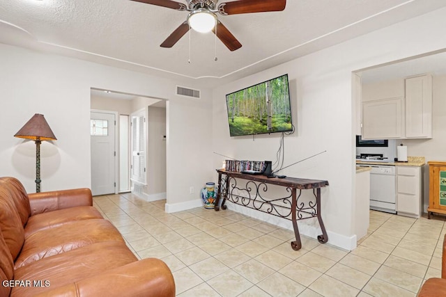 living area with visible vents, ceiling fan, baseboards, and light tile patterned floors