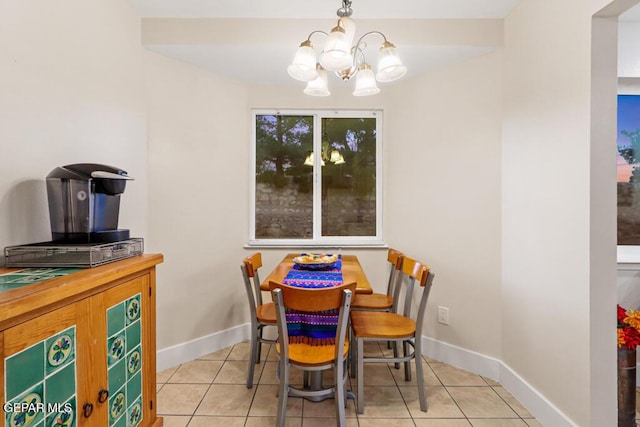 tiled dining room with baseboards and an inviting chandelier