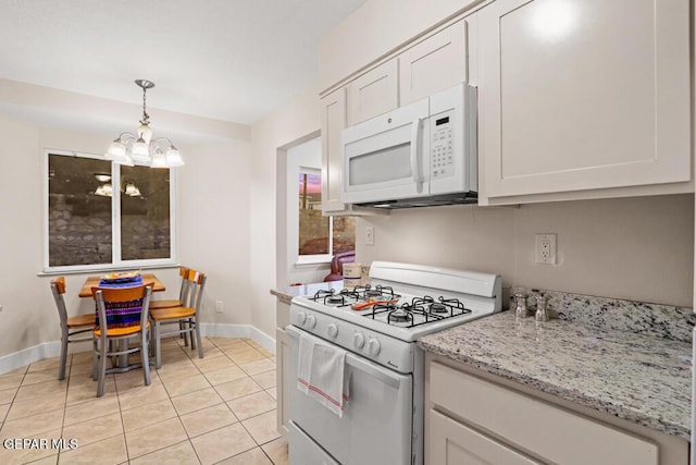 kitchen featuring light tile patterned floors, a notable chandelier, white appliances, baseboards, and decorative light fixtures