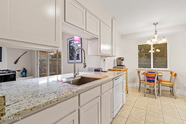 kitchen featuring light stone counters, decorative light fixtures, light tile patterned floors, a sink, and dishwasher