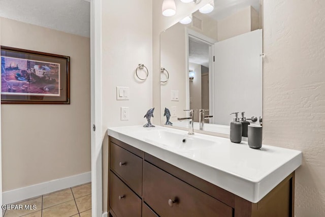 bathroom featuring vanity, baseboards, and tile patterned floors