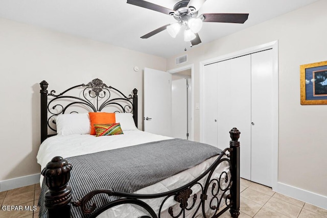 bedroom featuring a closet, visible vents, baseboards, and light tile patterned floors