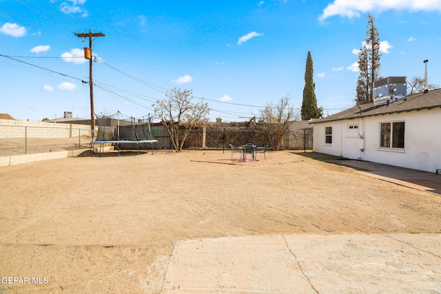 view of yard featuring a trampoline and a fenced backyard