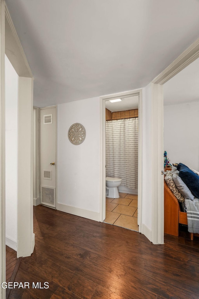 interior space with wood finished floors, visible vents, and baseboards