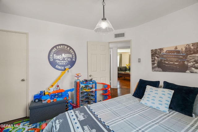 bedroom featuring visible vents and wood finished floors