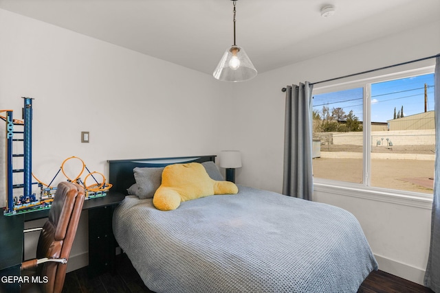 bedroom with baseboards and wood finished floors