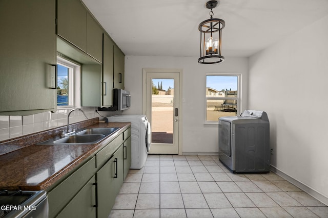 kitchen featuring dark countertops, tasteful backsplash, washer / clothes dryer, and a sink