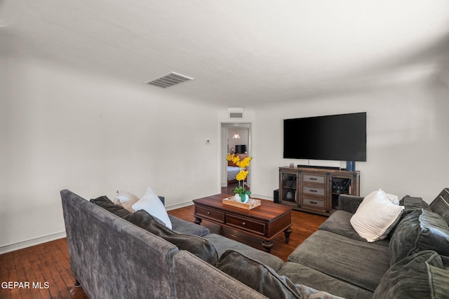 living area featuring baseboards, visible vents, and hardwood / wood-style floors