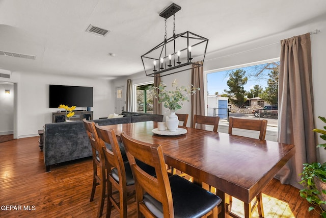 dining room with wood-type flooring, visible vents, and baseboards