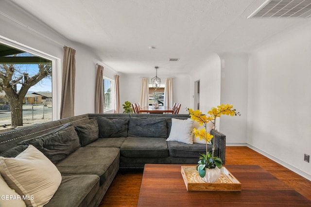 living area with wood finished floors, visible vents, and baseboards