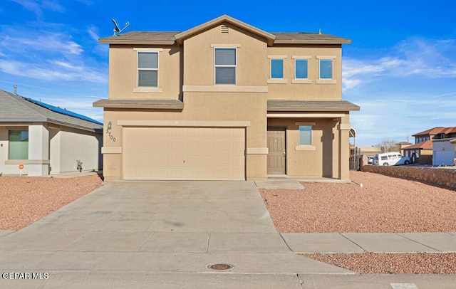 view of front facade featuring a garage, driveway, and stucco siding