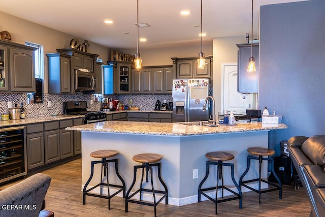 kitchen with wine cooler, a breakfast bar, appliances with stainless steel finishes, backsplash, and glass insert cabinets