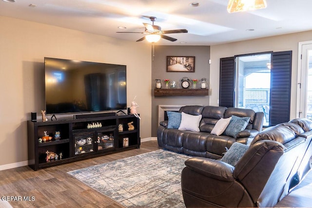 living area with a ceiling fan, baseboards, wood finished floors, and recessed lighting