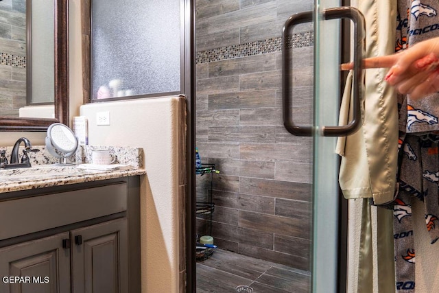 bathroom featuring a tile shower and vanity