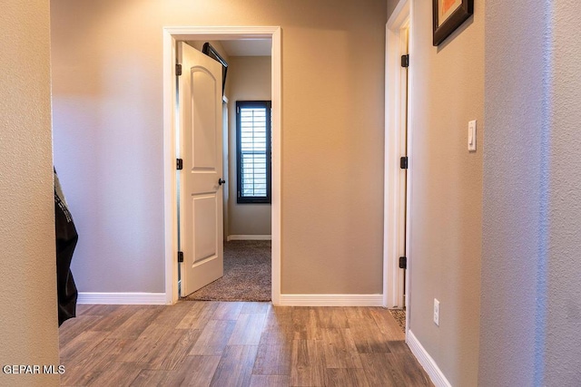 hallway with baseboards and wood finished floors