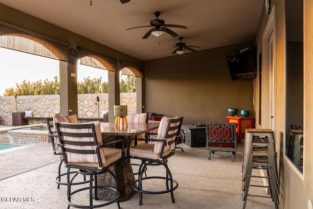 view of patio with outdoor dining space, fence, a ceiling fan, and an outdoor pool