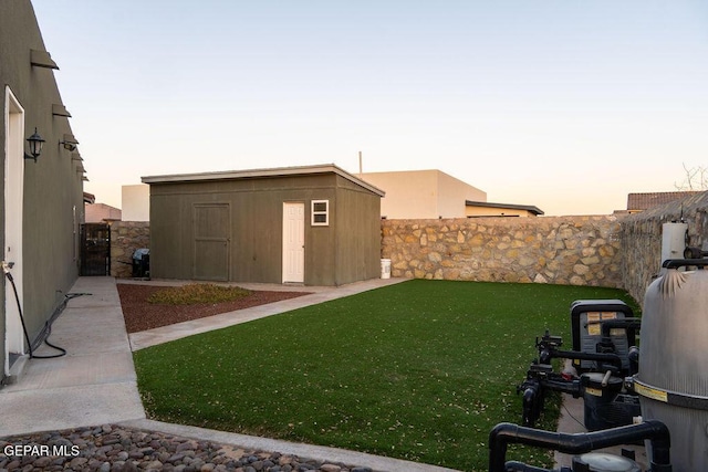 view of yard with a storage shed, fence, and an outbuilding