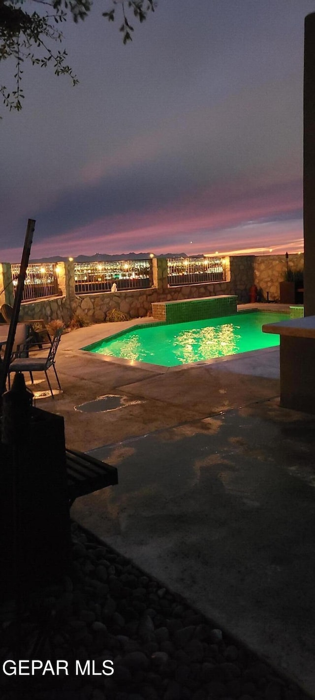 outdoor pool with a patio area and fence