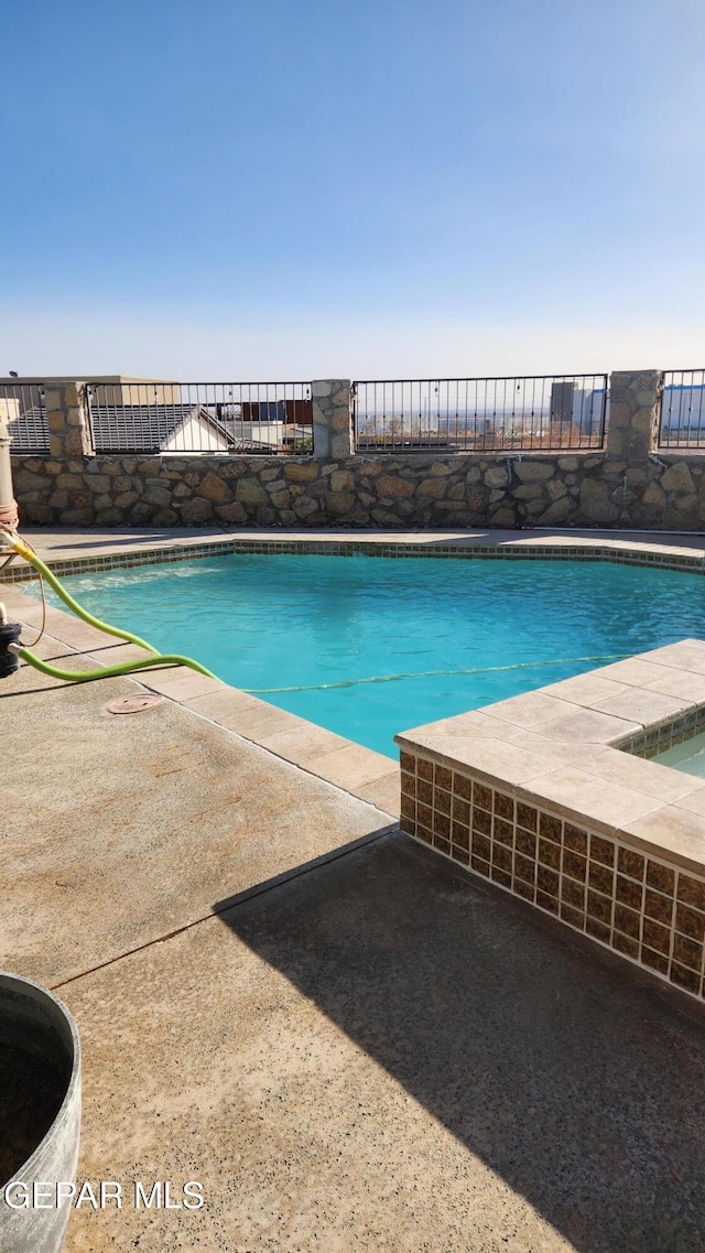 outdoor pool with a patio area