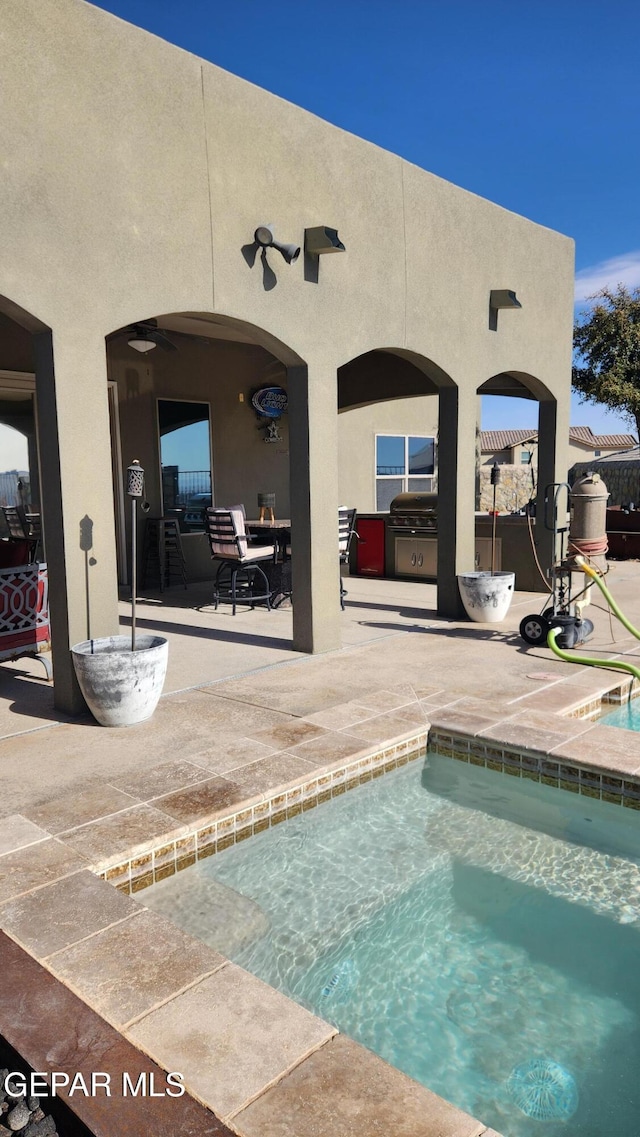 pool with a patio area and a ceiling fan