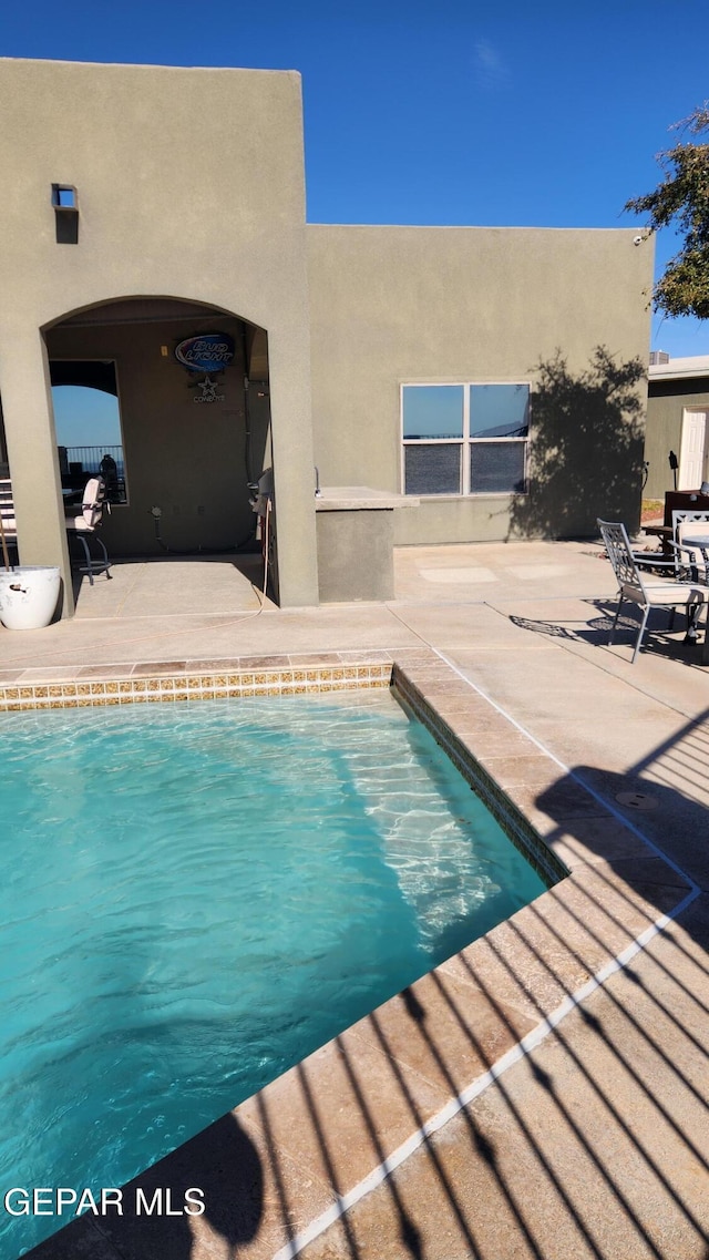 outdoor pool with a patio area