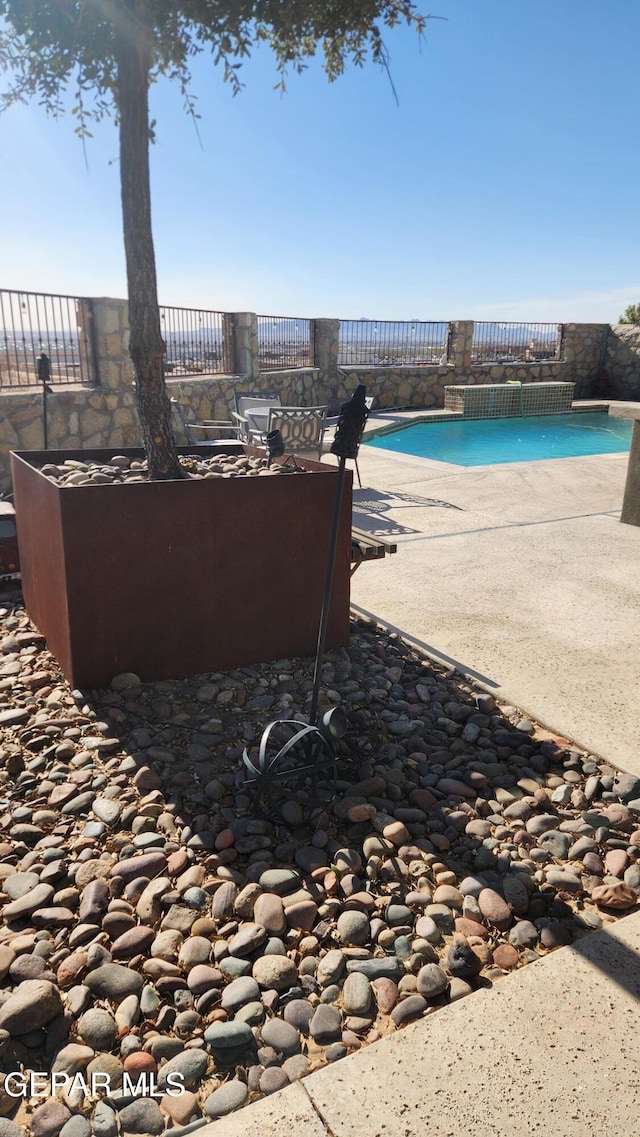 view of patio featuring an outdoor pool and fence