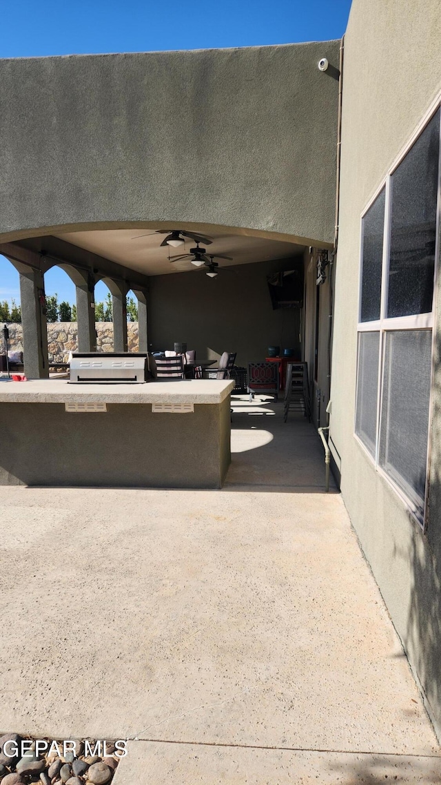 view of patio featuring a grill and a ceiling fan