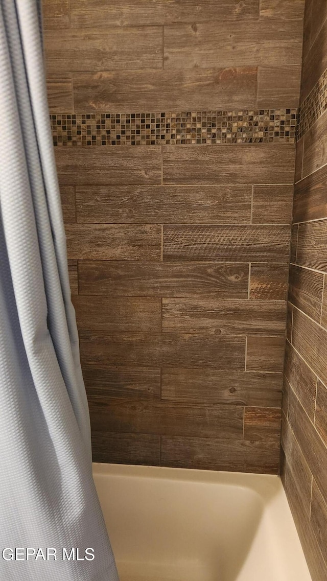 full bath featuring shower / tub combo with curtain