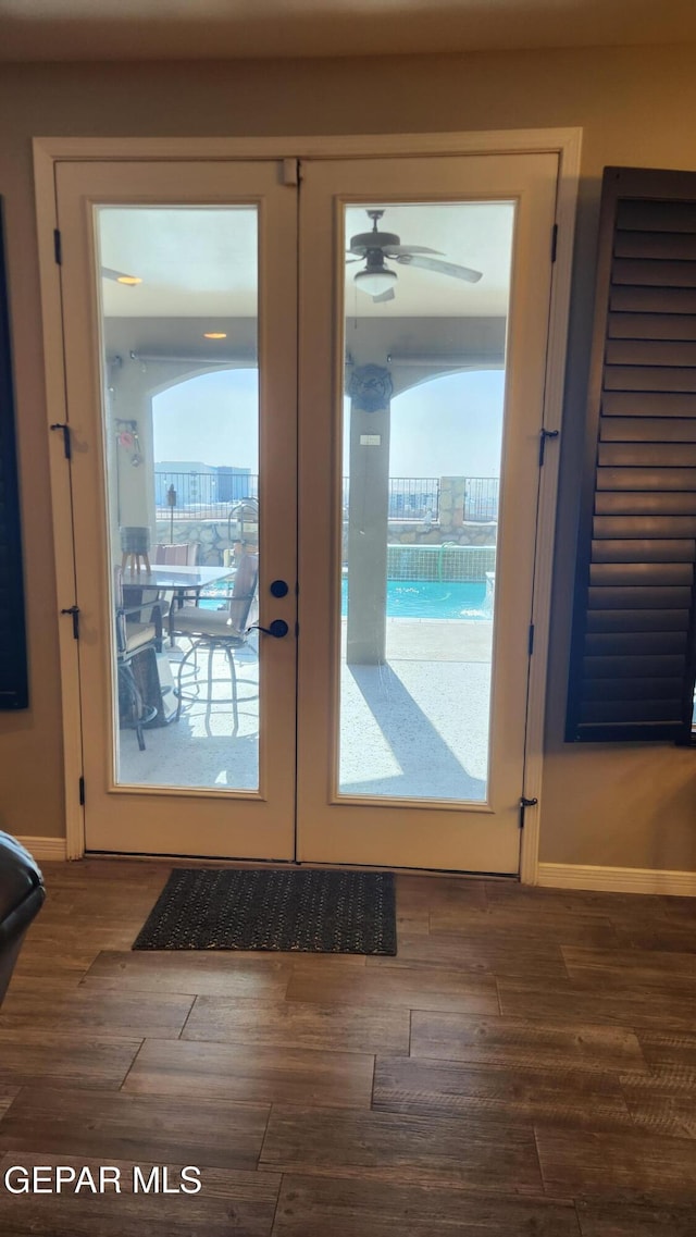 doorway with a wealth of natural light, french doors, baseboards, and wood finished floors