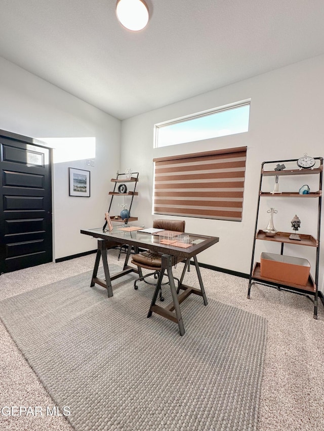 office featuring vaulted ceiling, carpet flooring, and baseboards