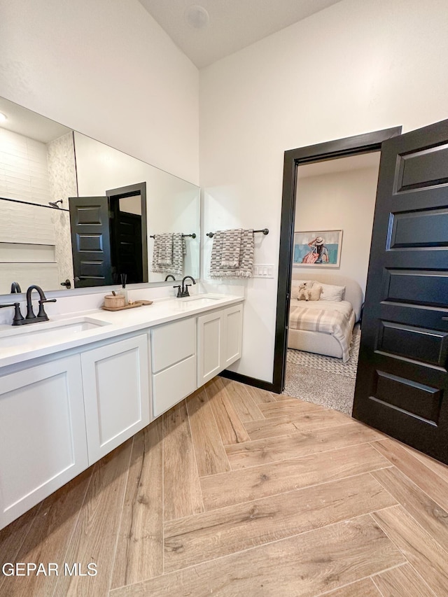 ensuite bathroom with double vanity, a sink, and ensuite bathroom