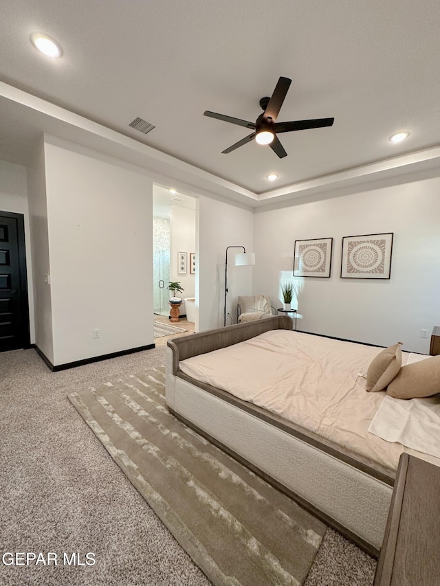 unfurnished bedroom featuring carpet floors, a tray ceiling, recessed lighting, visible vents, and baseboards