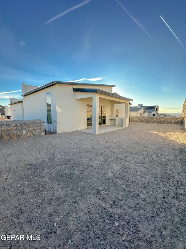 back of property featuring a patio, fence, and stucco siding