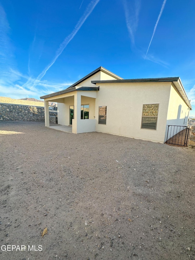 back of property with a patio and stucco siding