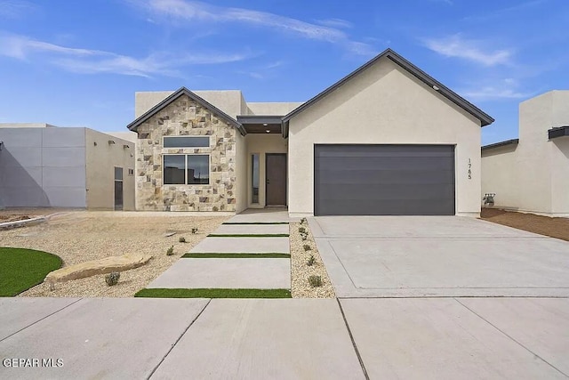 view of front of house featuring an attached garage, stone siding, driveway, and stucco siding