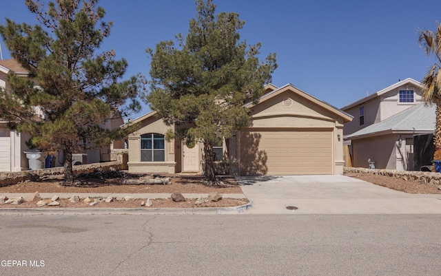 view of front of house featuring concrete driveway, an attached garage, and stucco siding