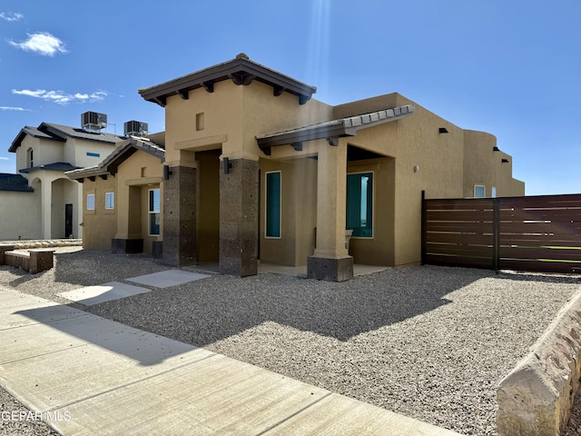 back of house with stucco siding, central AC unit, and fence