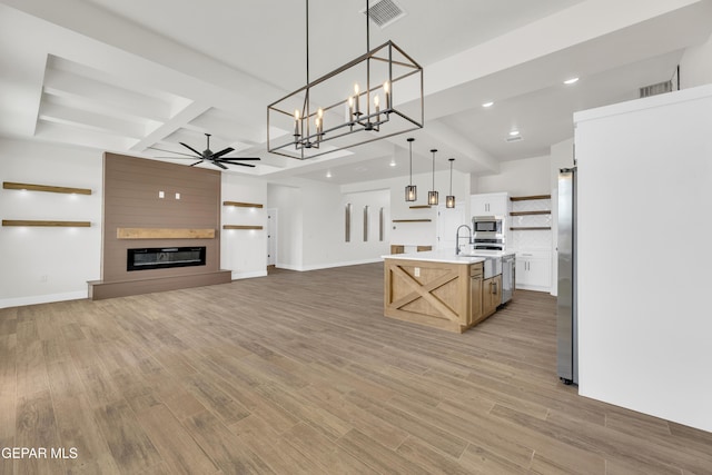 kitchen featuring open shelves, visible vents, a large fireplace, ceiling fan, and light wood-type flooring