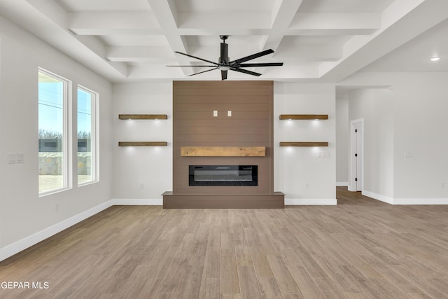 unfurnished living room featuring ceiling fan, coffered ceiling, a fireplace, wood finished floors, and baseboards