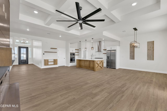 unfurnished living room with light wood-type flooring, coffered ceiling, baseboards, and ceiling fan with notable chandelier