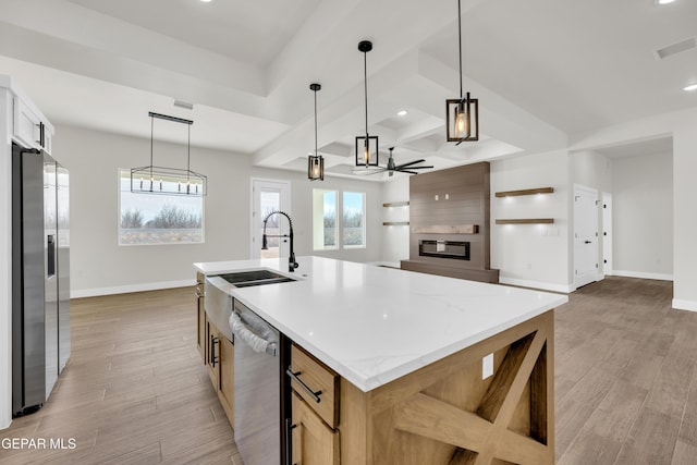 kitchen with appliances with stainless steel finishes, visible vents, a fireplace, and light wood finished floors