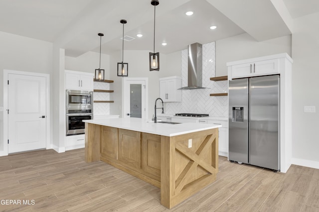 kitchen featuring appliances with stainless steel finishes, a sink, wall chimney exhaust hood, and open shelves