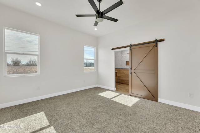 unfurnished bedroom with a barn door, baseboards, a ceiling fan, carpet floors, and recessed lighting