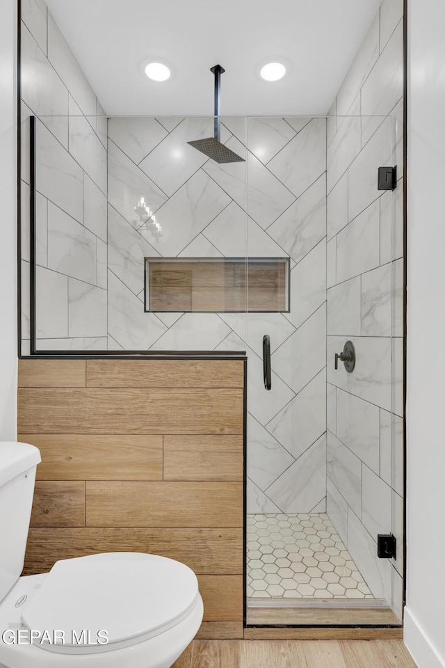 bathroom with a stall shower, toilet, and recessed lighting