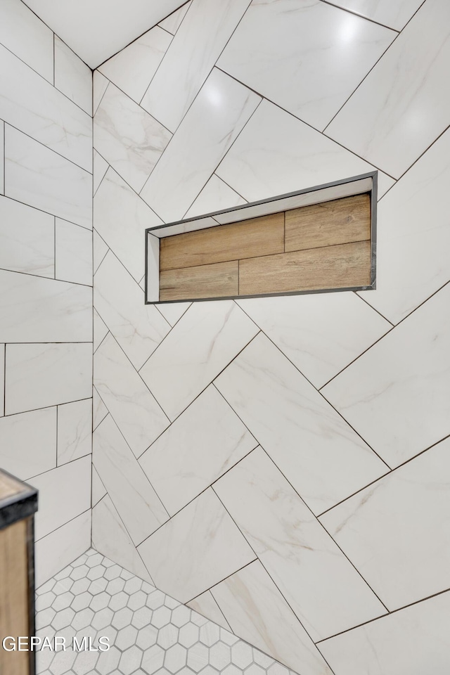 interior details with a tile shower