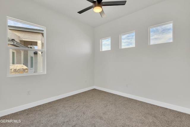 carpeted spare room featuring a ceiling fan and baseboards